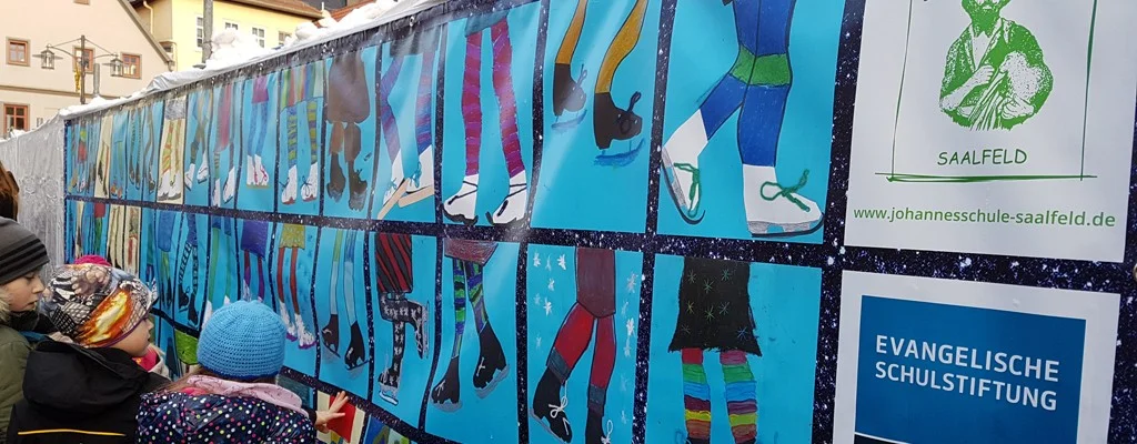 Die Kinder der Evangelischen Johannesschule Saalfeld können sich auch in den Ferien an ihre Schule erinnern: Sie haben im Kunstunterricht diese Schlittschuhbilder angefertigt, die nun die Eisbahn in Saalfeld schmücken.