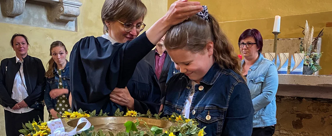 Eine Schülerin der Evangelischen Grundschule Hettstedt wird im Beisein der gesamten Schulgemeinschaft getauft.