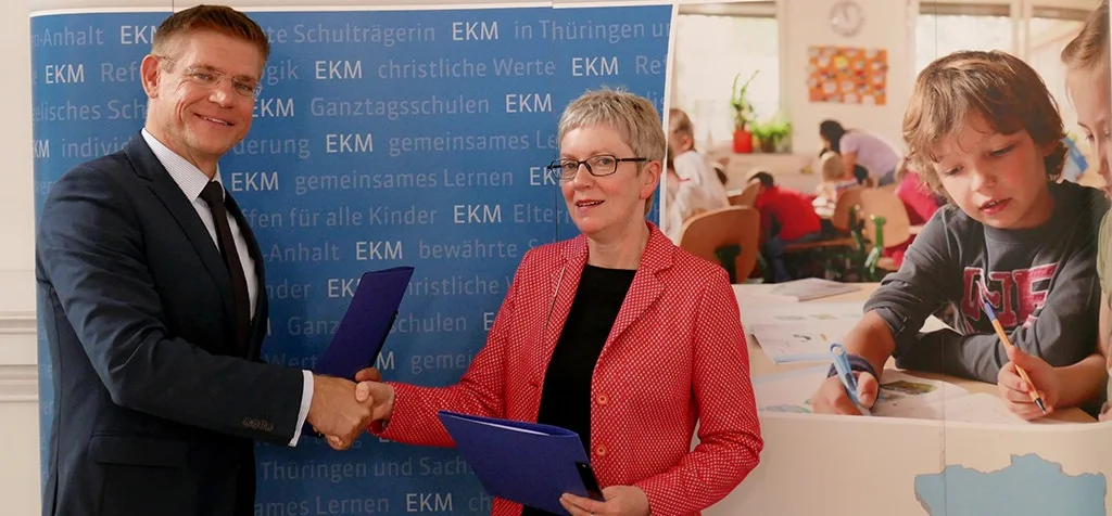 Andrea Schulte und Marco Eberl halten die eben unterzeichnete Kooperationsvereinbarung in Händen.